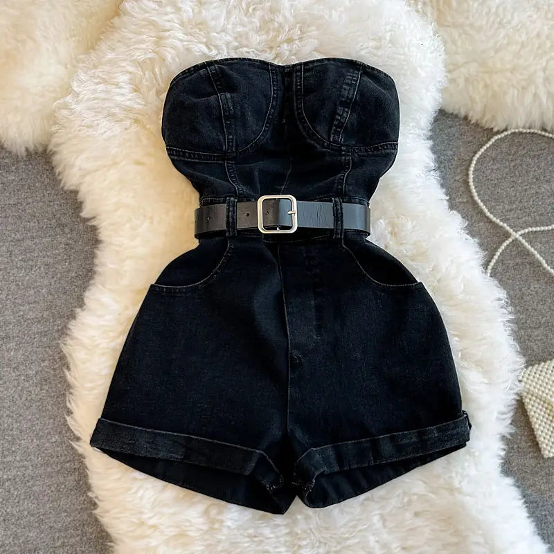 Black denim romper with a belt on a fluffy white surface