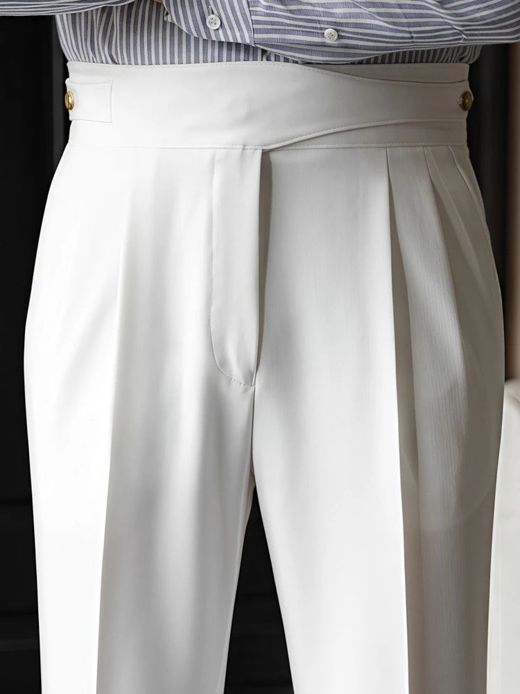 White pleated pants worn with a striped shirt on a black background