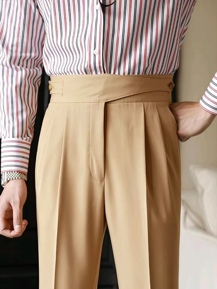 Person wearing a striped shirt and beige pants with a neutral background