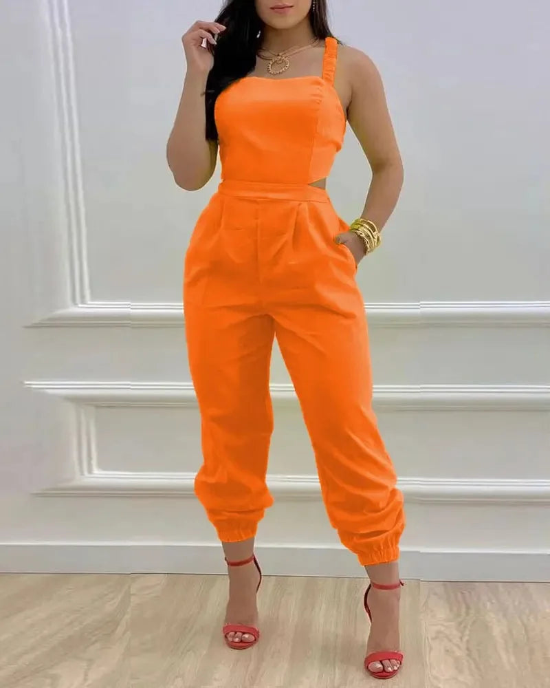 Person wearing an orange jumpsuit against a white wall.