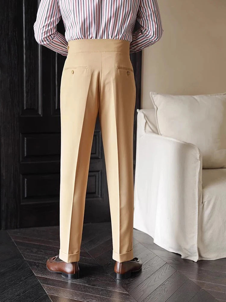 Person wearing beige pants and a striped shirt in a room with a white couch.