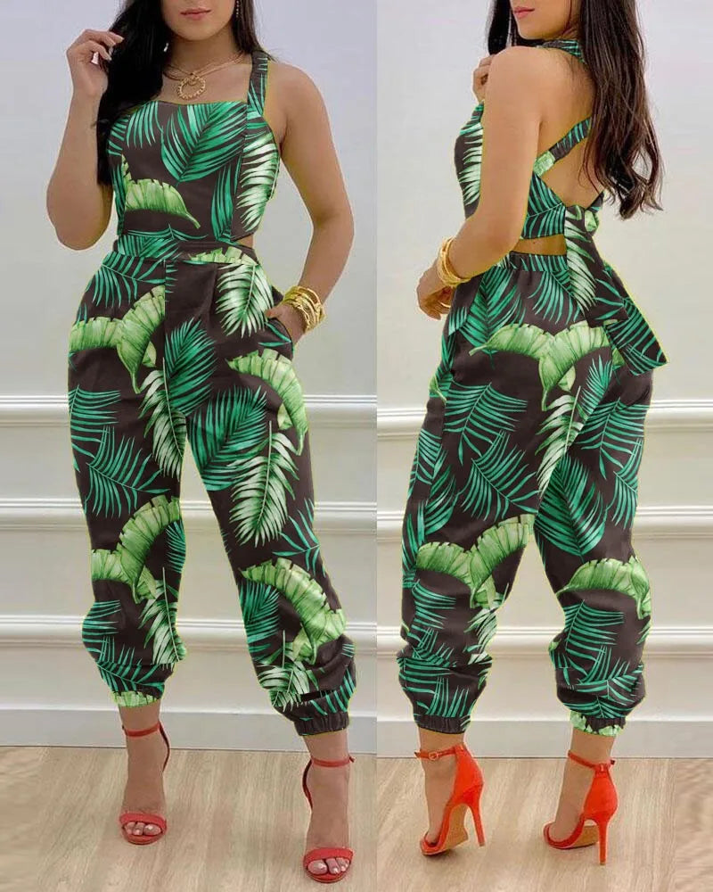 Woman wearing a green and black leaf-patterned jumpsuit with red high heels.